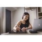 Person studying at desk with laptop and writing tablet, using Attenu8 earplugs to enhance focus and reduce distractions, available at Ideale Lifestyle e-commerce store