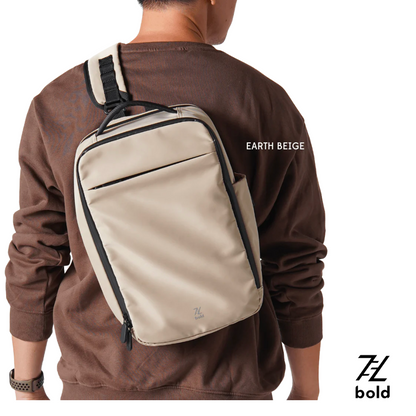 Bold Quiver 13L Earth Beige minimalist sports backpack with black trim, worn crossbody by man in brown sweatshirt, featuring front zipper pocket and compact rectangular design