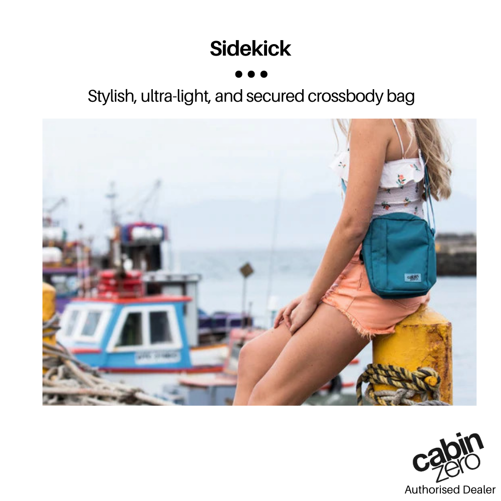 CabinZero Sidekick 3L Sling Bag lifestyle photo—blue ultra-light crossbody bag styled for summer, travel, and daily adventures by the marina