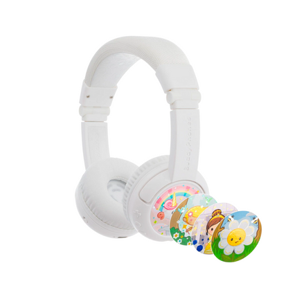 White over-ear kids’ headphones with a cushioned headband, shown with four interchangeable decorative discs featuring a unicorn, fairy, princess, and smiling flower on a white background